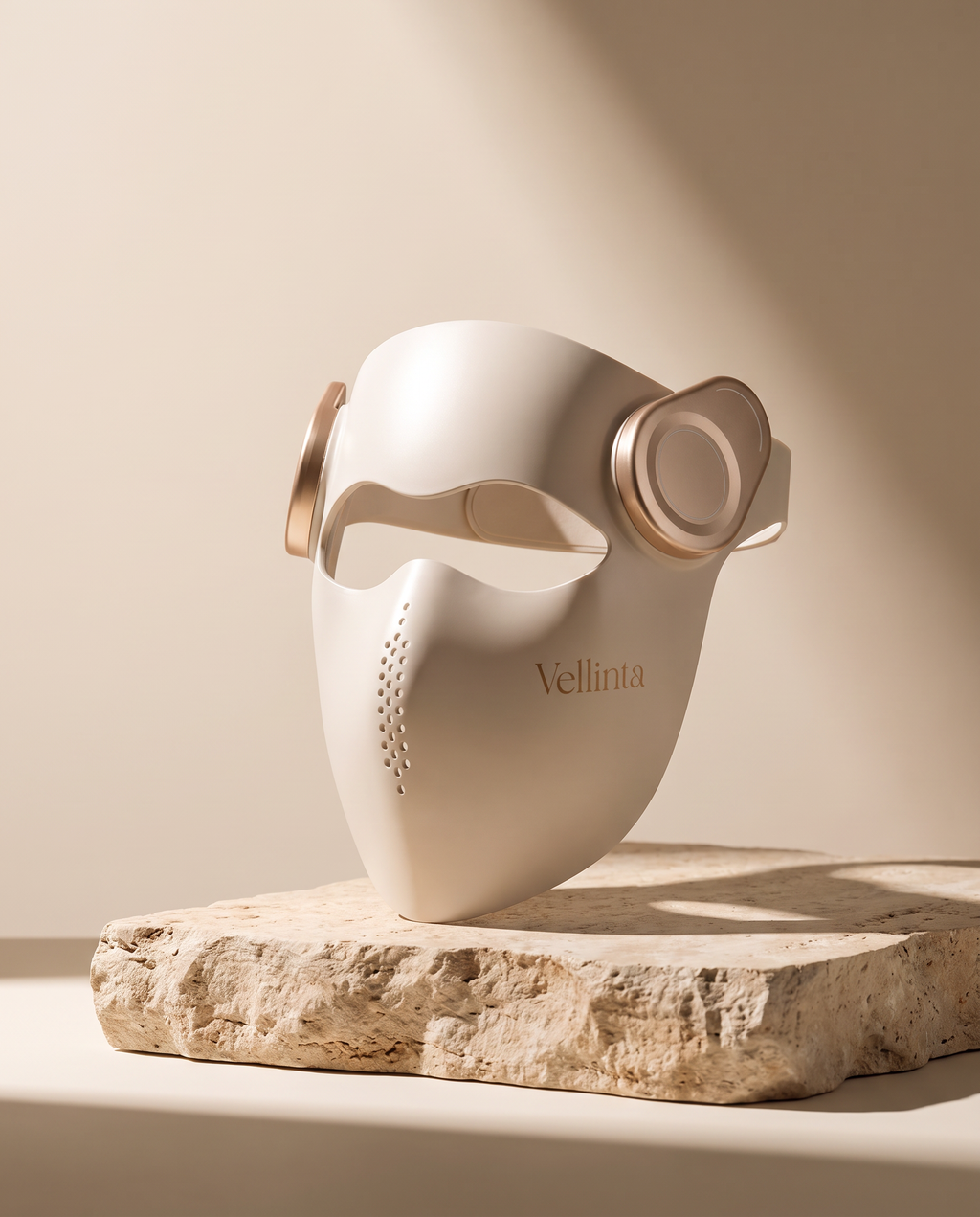 Vellinta Lumina Pro LED face mask standing on a travertine stone plinth in soft studio light