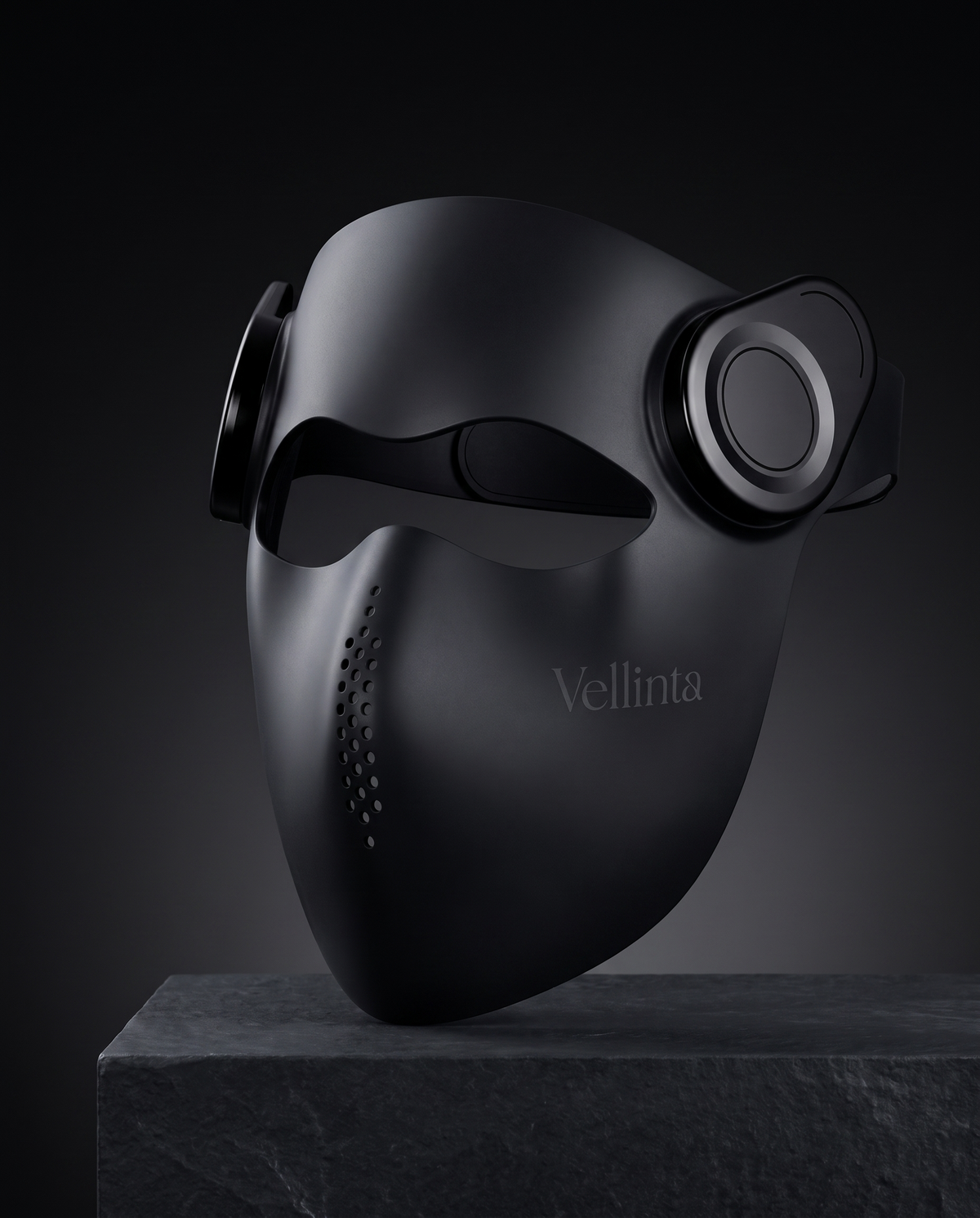 Vellinta Lumina Pro red light therapy mask in matte black on a dark slate plinth
