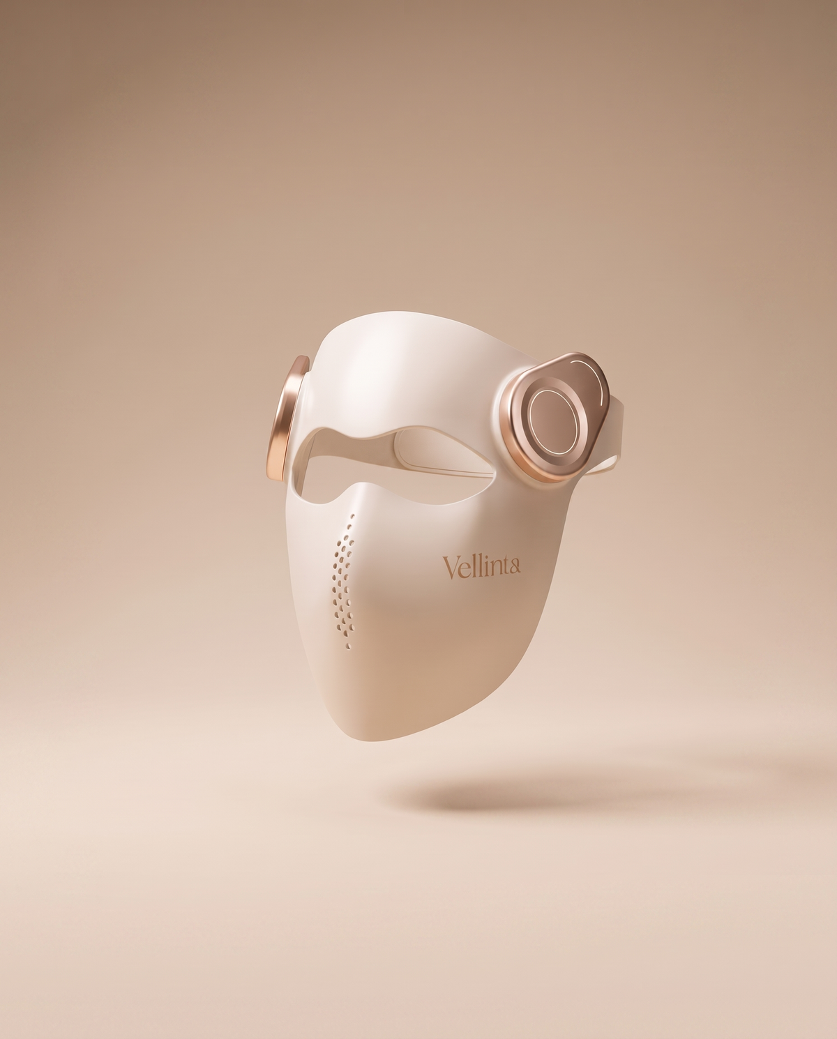 Vellinta Lumina Pro in Champagne, red light therapy mask floating against a warm sand backdrop